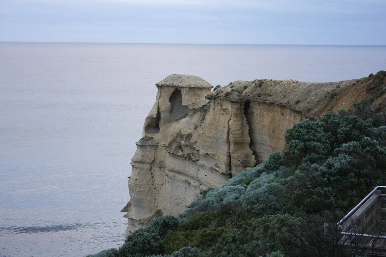 A limestone sea stack rising from the Southern Ocean beside the cliffs of the Great Ocean Road in Victoria