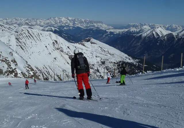 Skiers and snowboarders on a wide groomed piste at the Kreuzkogel in the Sportgastein ski area, Austria