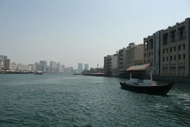A traditional wooden abra water taxi crossing Dubai Creek between the Deira and Bur Dubai waterfronts