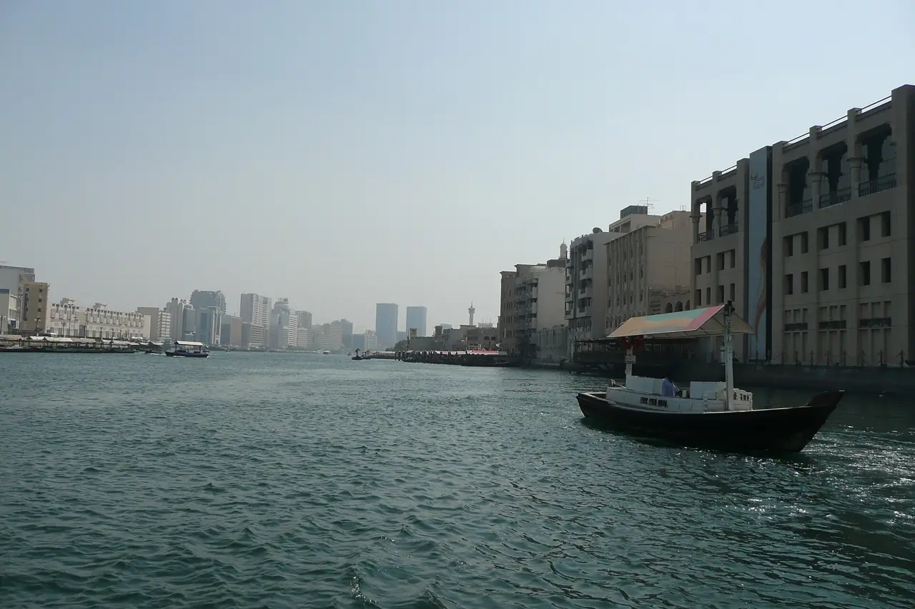 A traditional wooden abra water taxi crossing Dubai Creek between the Deira and Bur Dubai waterfronts