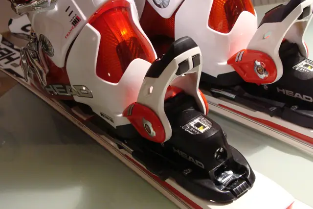 Close-up of red and white ski bindings mounted on a pair of skis