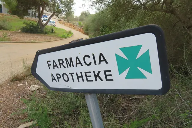 A roadside pharmacy sign reading Farmacia and Apotheke in Mallorca, Spain