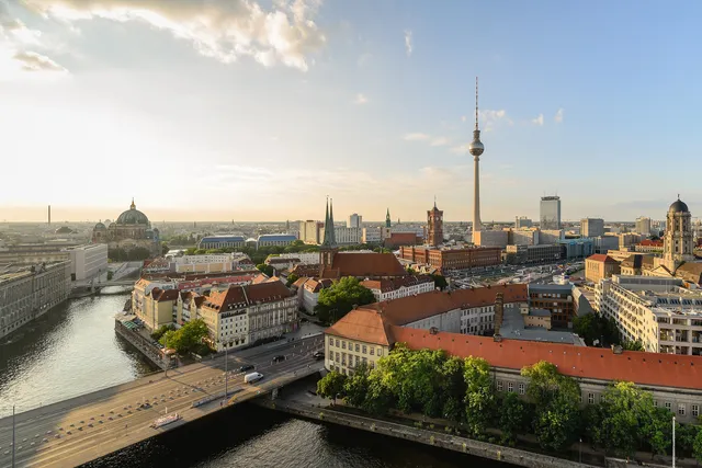 Berlin Mitte skyline at sunset with the Spree river, the Berliner Dom dome and the Fernsehturm TV tower rising above the rooftops