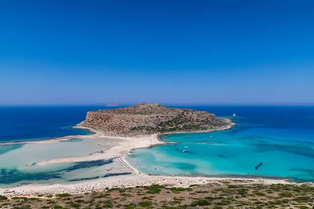 Aerial view of Balos Lagoon on Crete, with white sand and shallow turquoise water around the Cape Tigani headland
