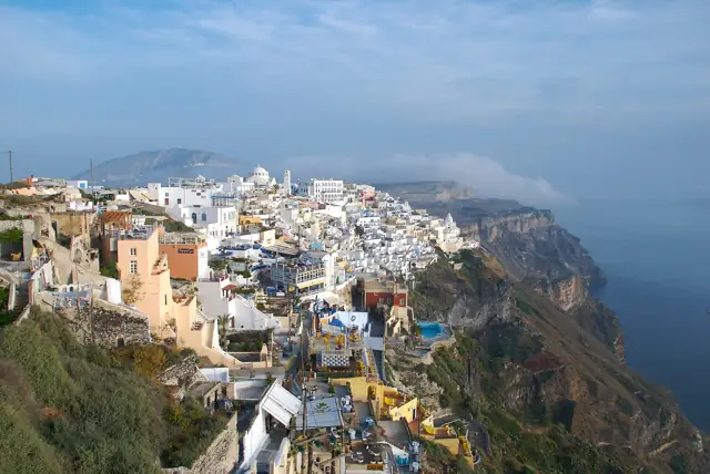 White houses of Fira clinging to the caldera cliffs of Santorini above a deep blue sea