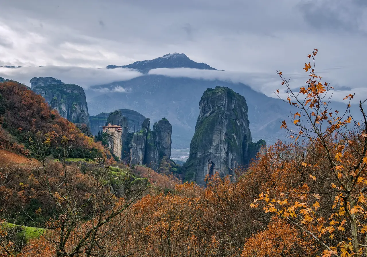 Rousanou Monastery on a rock pinnacle among the sandstone towers of Meteora with autumn trees in the foreground