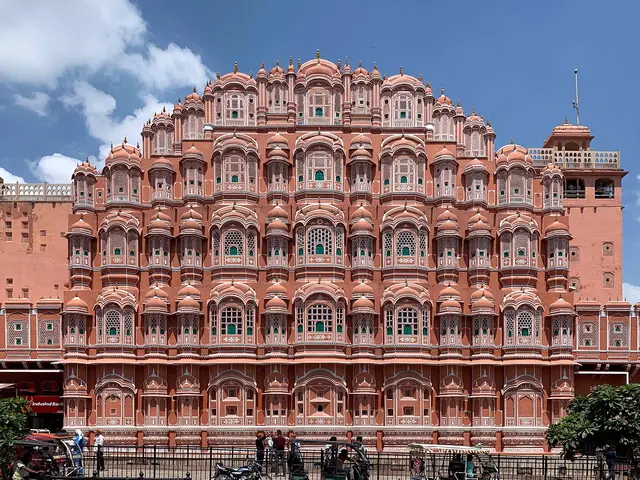 The pink sandstone façade of the Hawa Mahal, the Palace of the Winds, in Jaipur under a blue sky