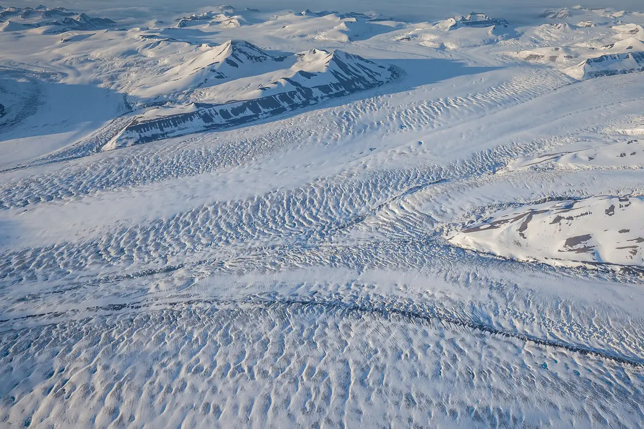 Aerial view of the snow-covered Nathorst glacier on Svalbard glowing under the midnight sun