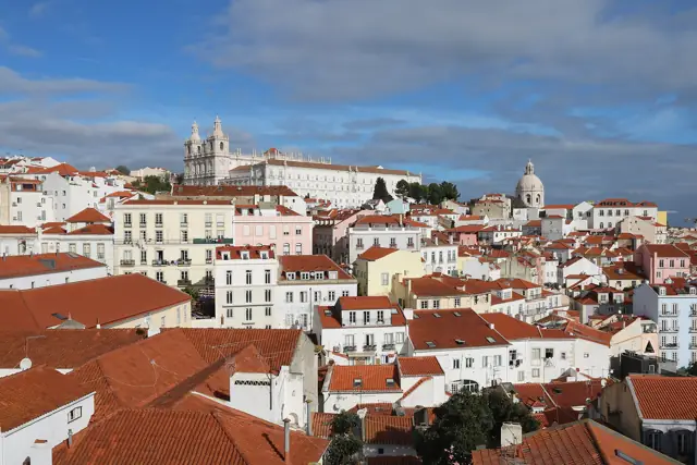 Terracotta rooftops of Alfama in Lisbon with the dome of the National Pantheon and São Vicente de Fora church behind
