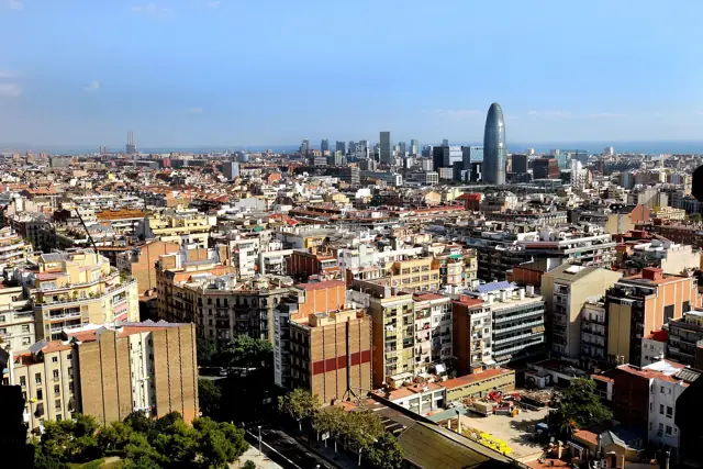 View over Barcelona's rooftops towards the Mediterranean coast and the Torre Glòries tower