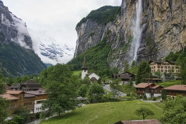 Staubbach Falls plunging from a sheer cliff above the village of Lauterbrunnen in a green Alpine valley